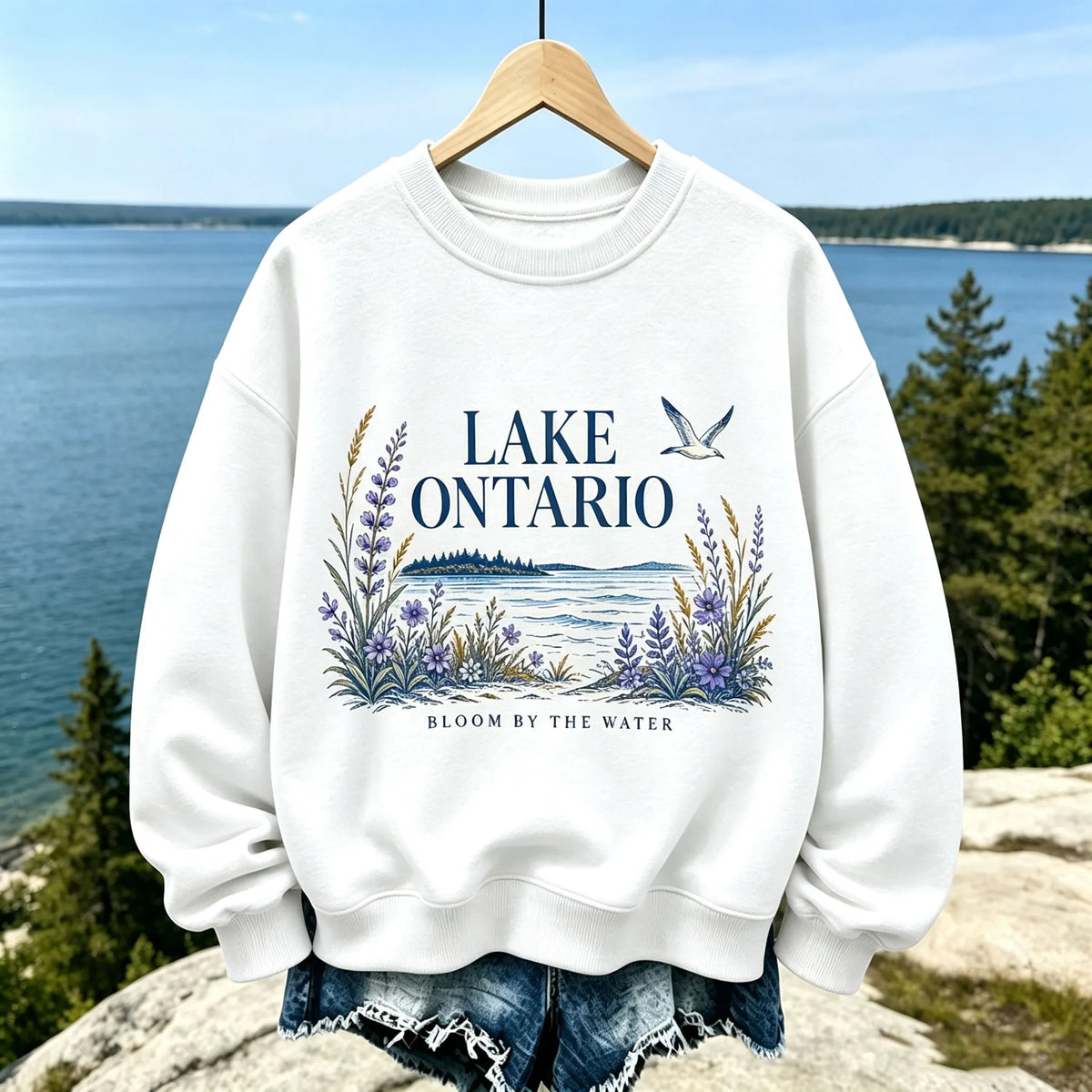 Women's Casual Crewneck Sweatshirt In Cream With Lake Ontario Water, Purple Lupine Flowers, And "bloom By The Water" Print